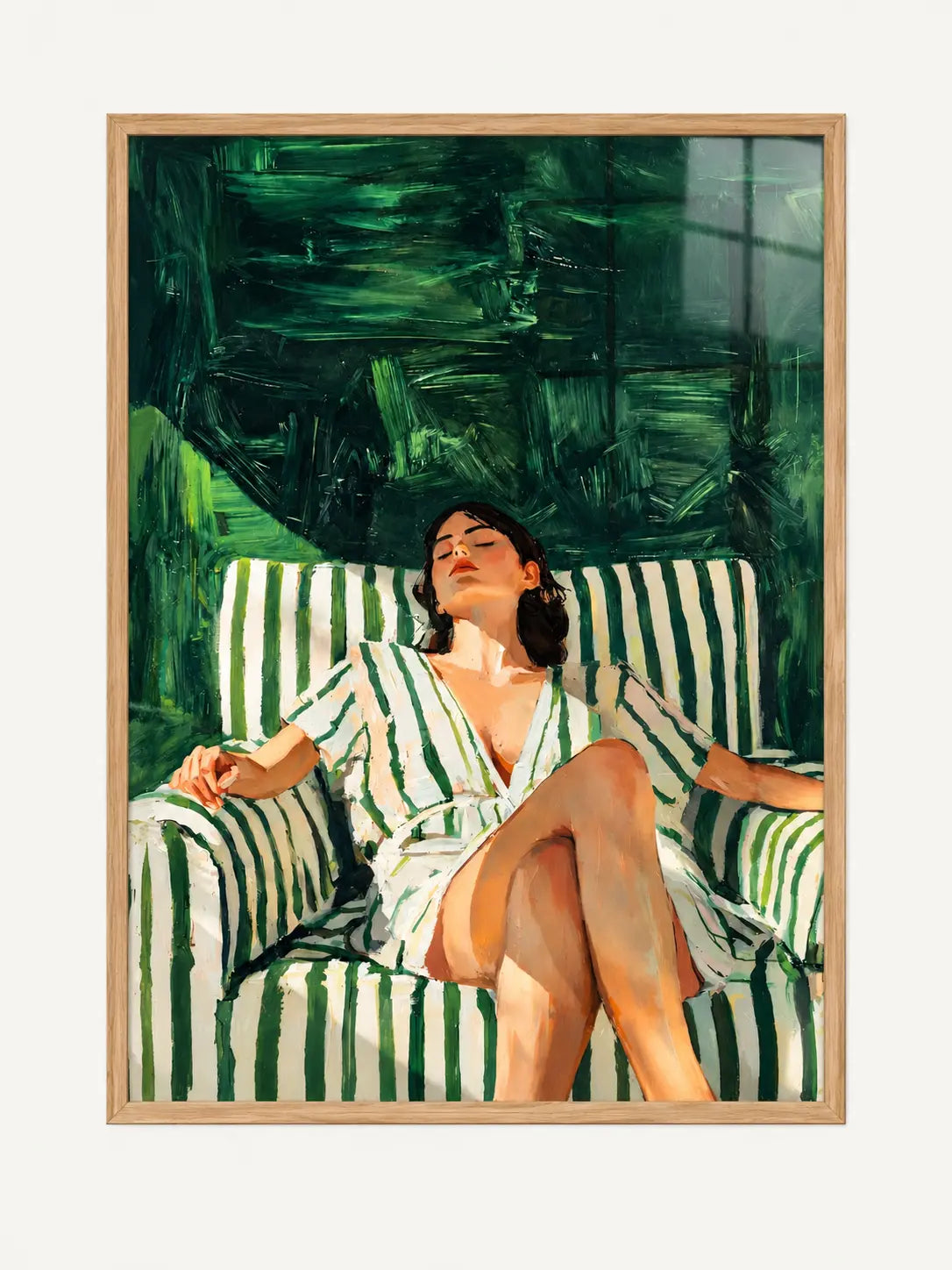 Woman relaxing in a green and ivory striped armchair, painterly A3 wall art in a light oak effect frame